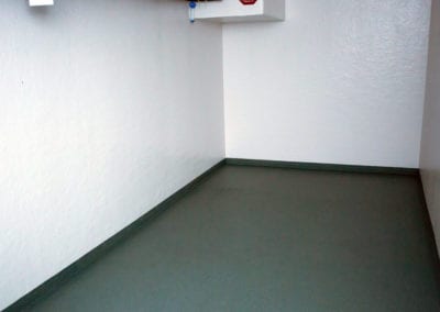 Inside of a polar leasing commercial refrigerator with white walls and grey flooring