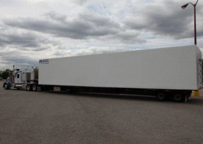 Large white portable walk in cooler on a semi truck